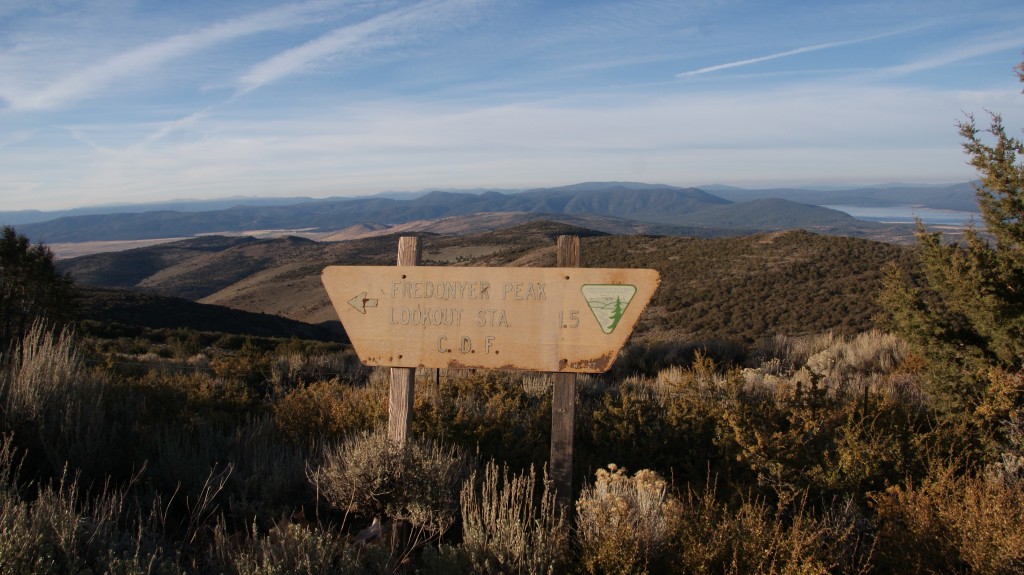 Sign at the Fredonyer Peak locked gate, Eagle Lake in the background with Mt Lassen way off in the distance.